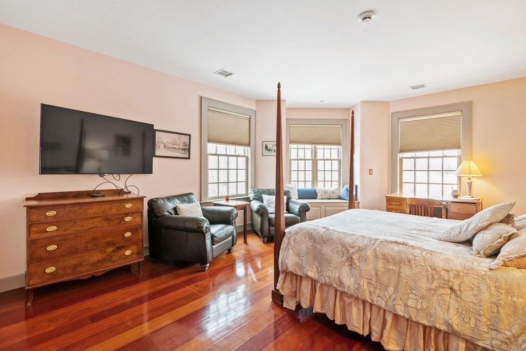 The bedroom features a canopy bed, and the wooden flooring gives off a rustic feel to the room.