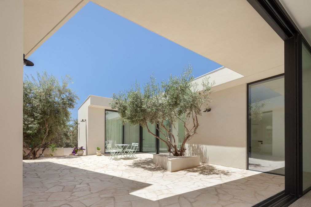 This is a photograph captured from inside the dwelling, offering a view of the outdoor area through its glass walls.