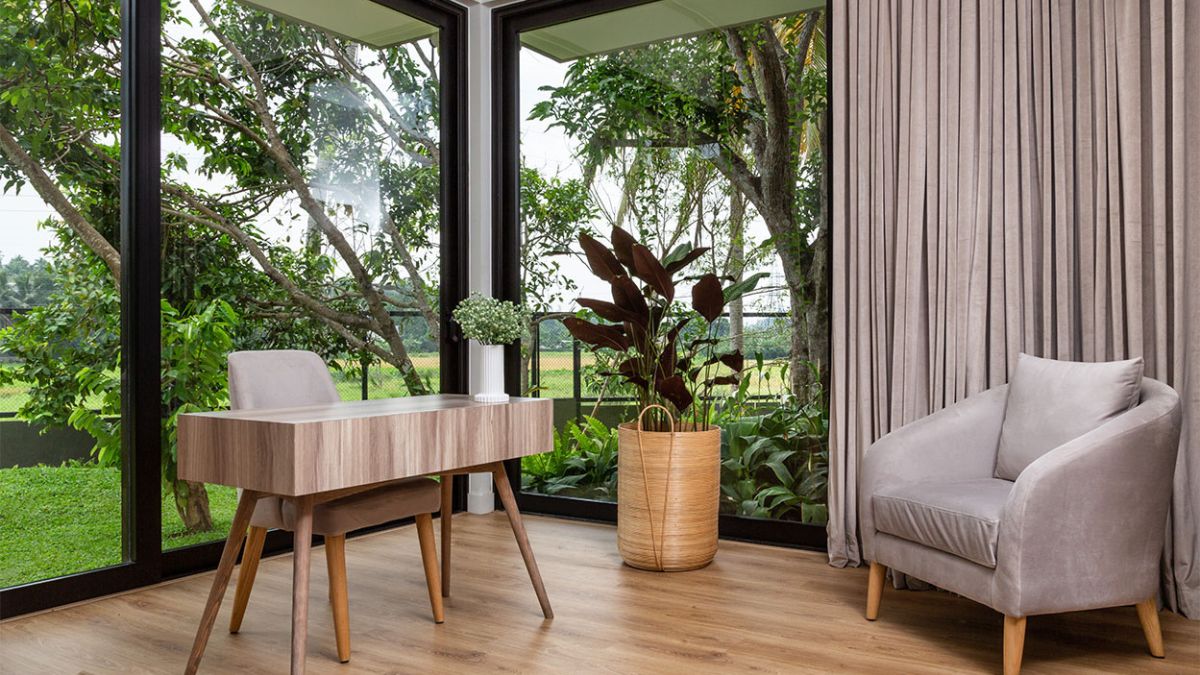 This interior photograph highlights the seamless integration of a room with the surrounding garden through the use of expansive glass wall panels, creating a sense of harmony and tranquility that enhances the overall ambiance.