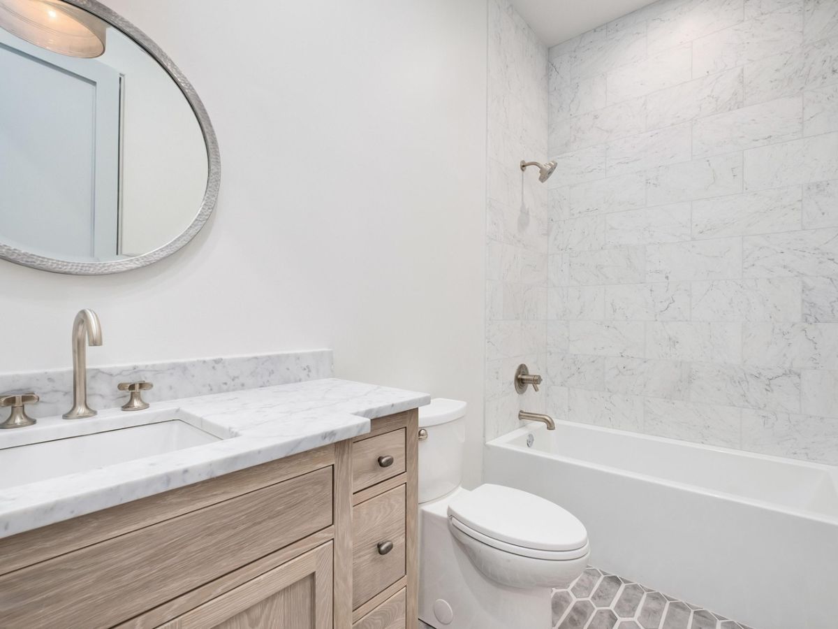 The bathroom features a built-in bathtub and a vanity with a granite countertop.