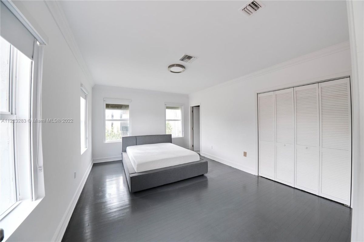 The bedroom features wooden flooring and a double-size bed.