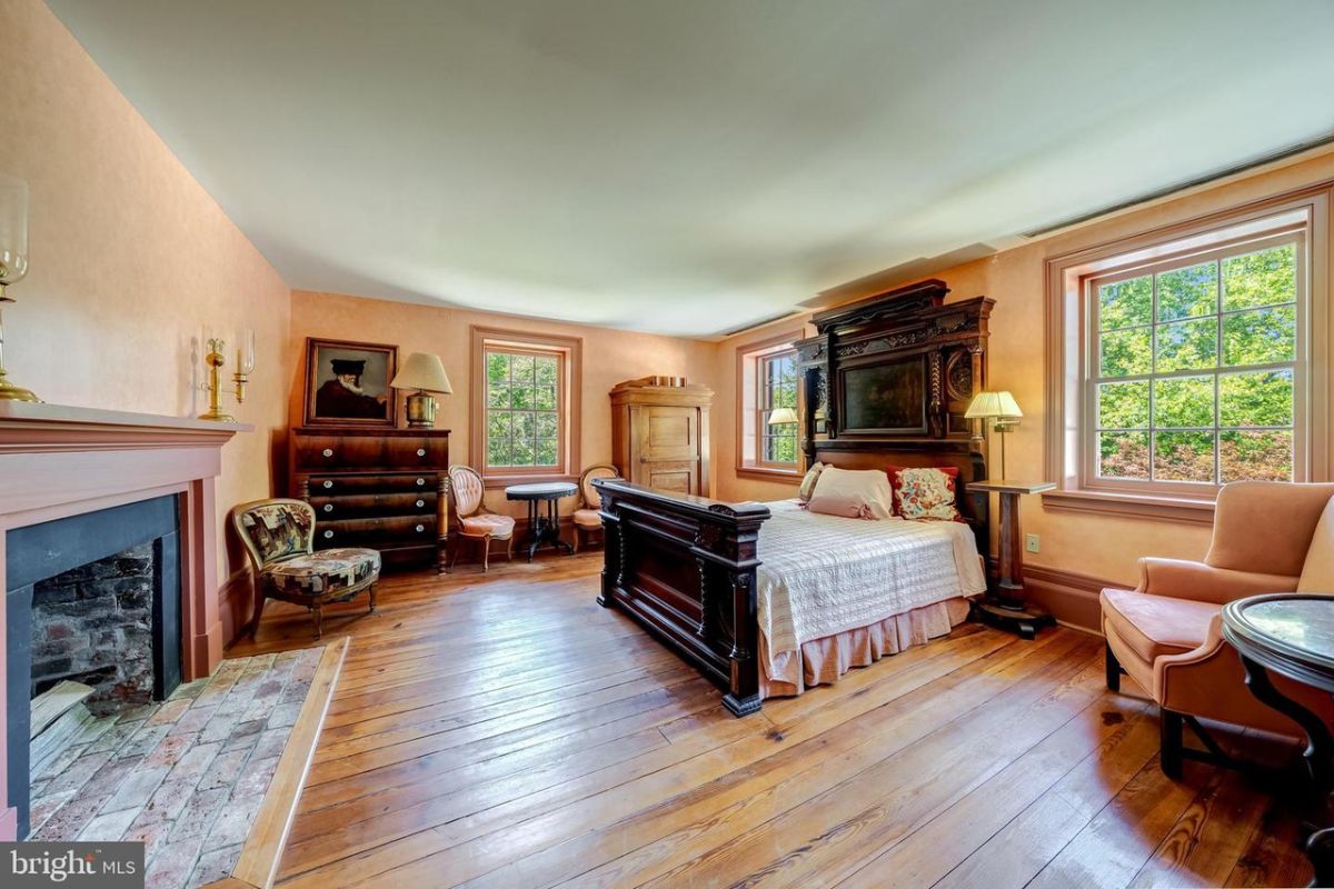 The bedroom features a queen-size bed with a wooden headboard and a fireplace that keeps the room warm.