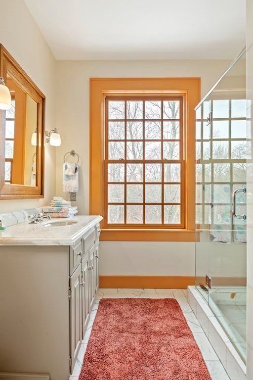 The bathroom features a shower cubicle with a glass enclosure and a vanity with a tile countertop.