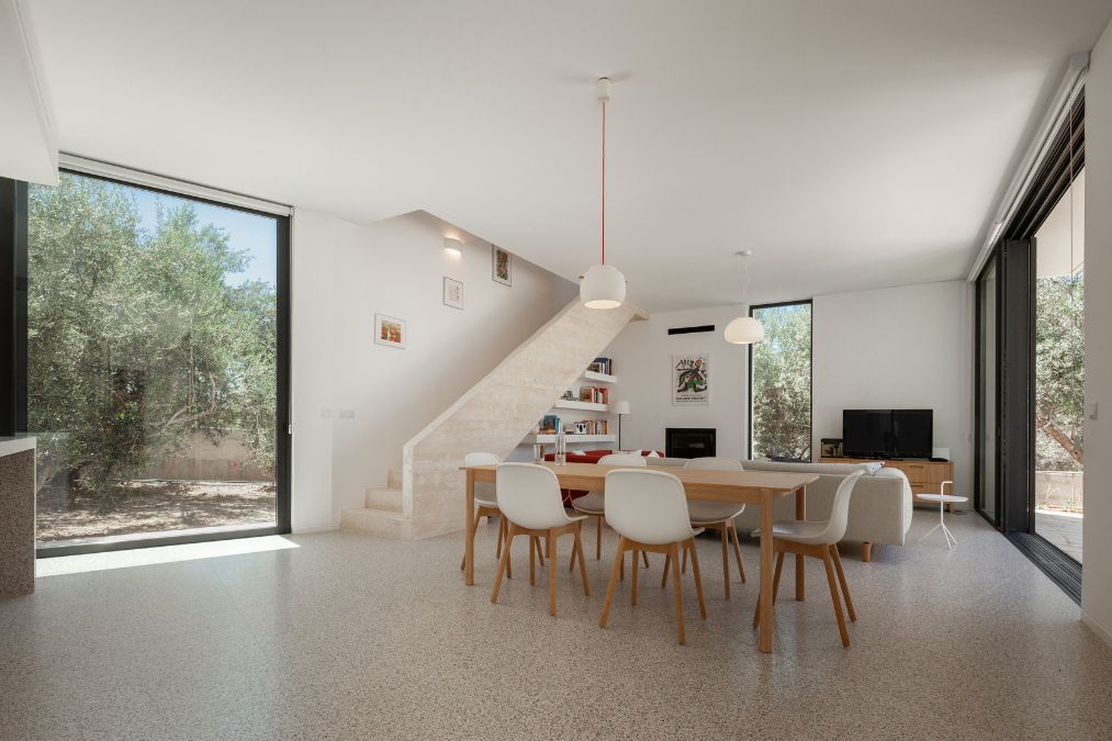 This is an interior photograph highlighting the dining area and its interior design, with an adjacent view of the staircase.