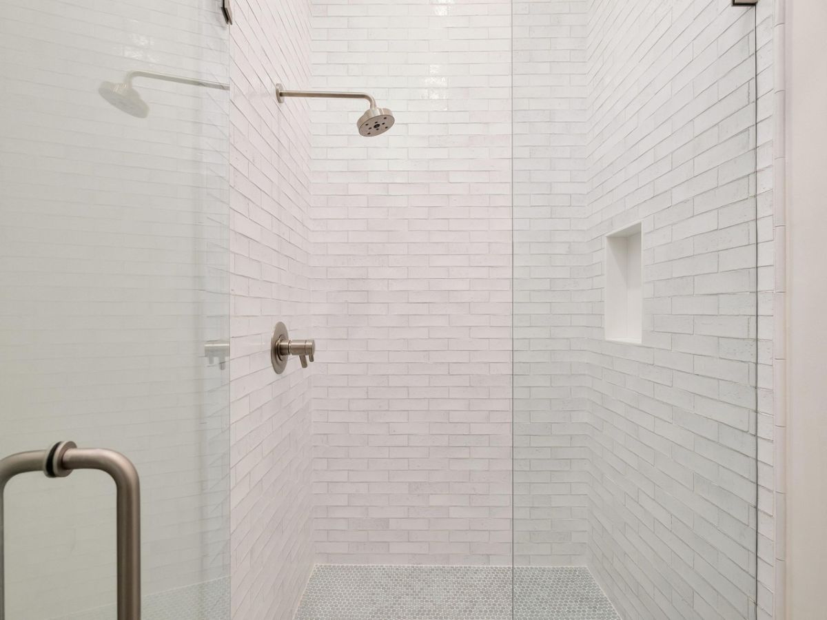 The shower cubicle features tile walls and a glass enclosure.