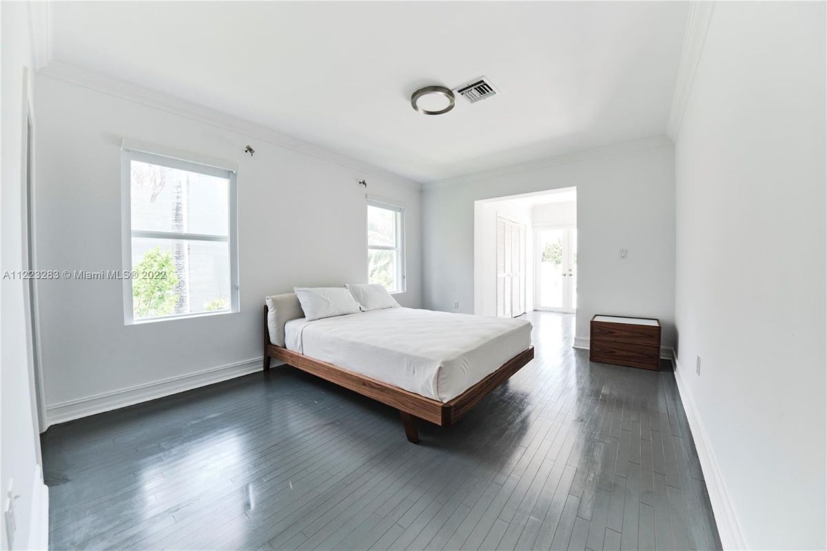 The bedroom features a double bed, and the glass windows showcase the sea.