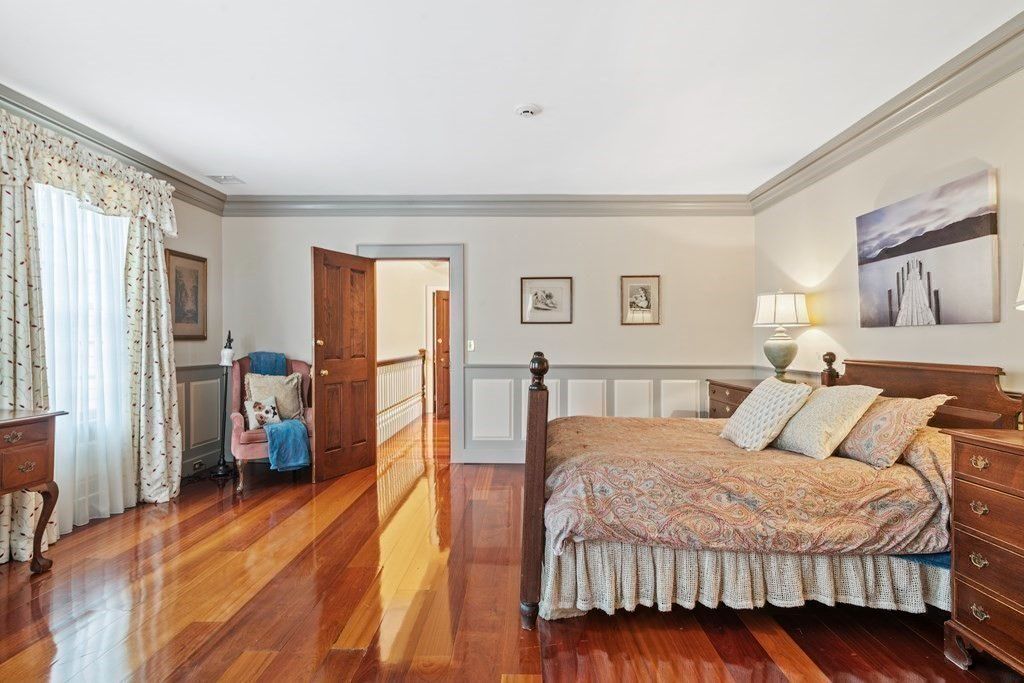 The bedroom features a wooden bed that blends well with the polished wooden flooring giving off a rustic feel.