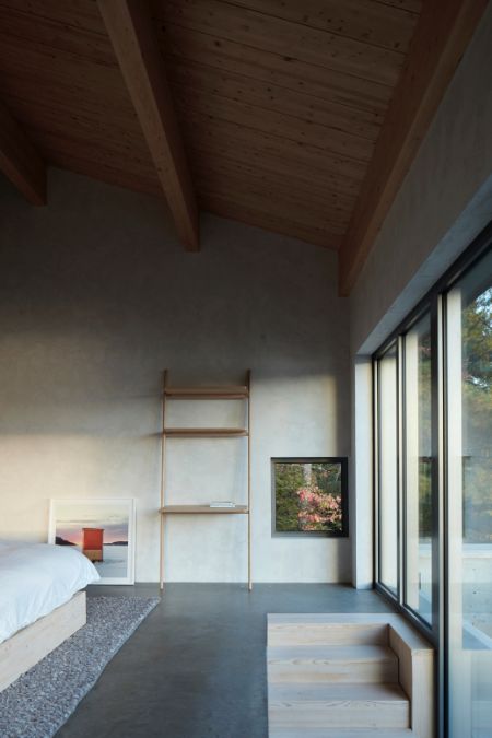 An upper-level bedroom is highlighted, featuring its interior design with a bed, a ladder, and expansive glass windows.