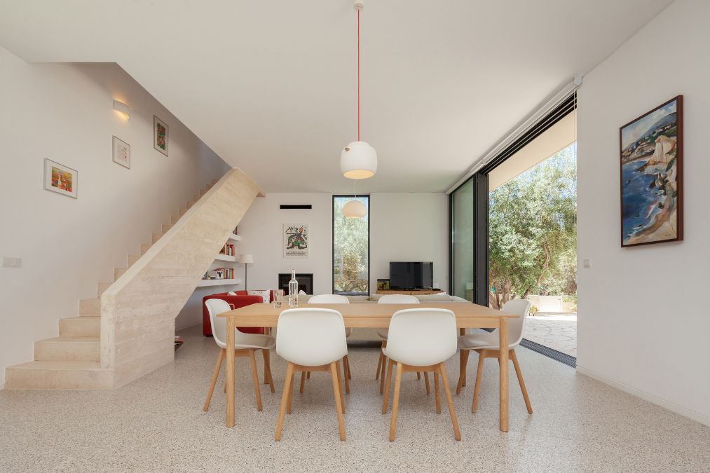 This is an alternative interior photograph of the dining area, showcasing its interior design from a distinct perspective and featuring an adjacent view of the staircase.