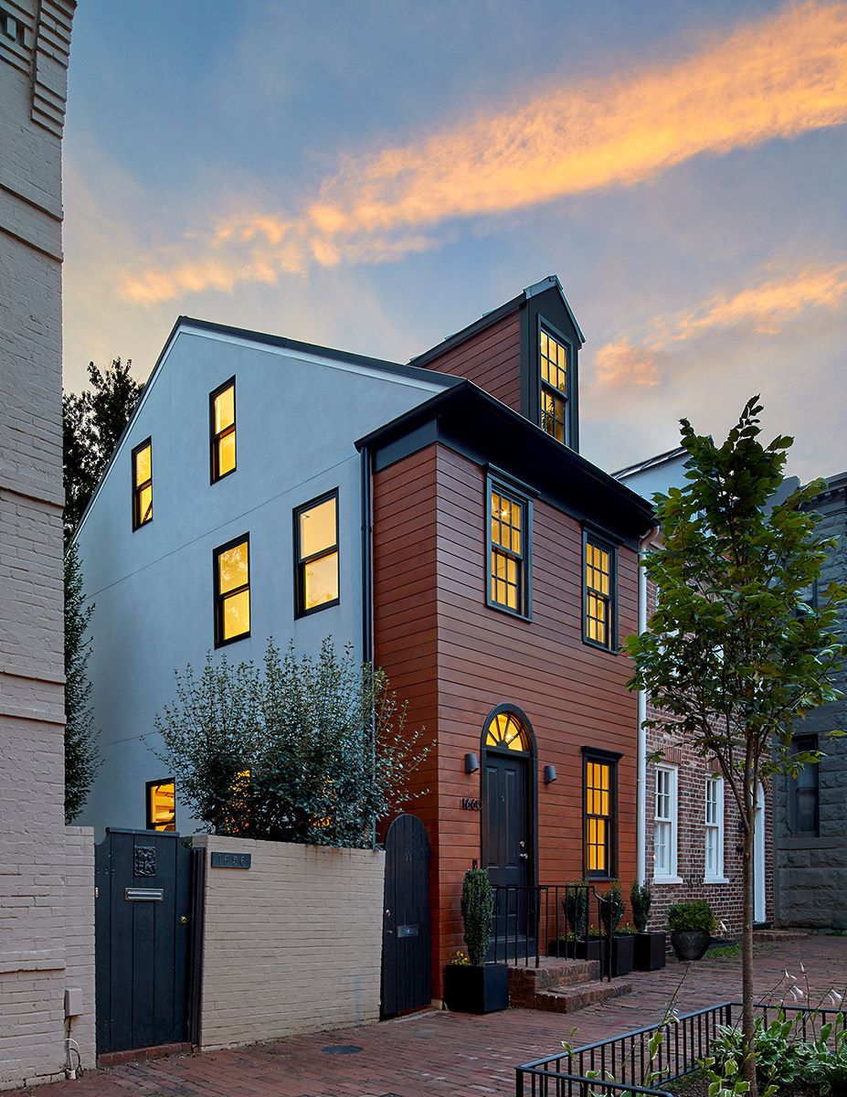 The restoration of the street façade preserves the cottage's character and connection with the surrounding historic context.