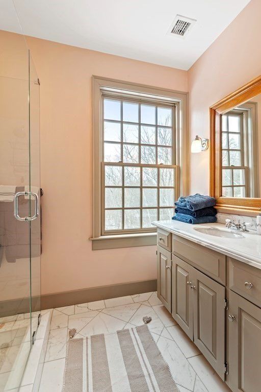 The bathroom features a vanity with a tile countertop and a shower cubicle.