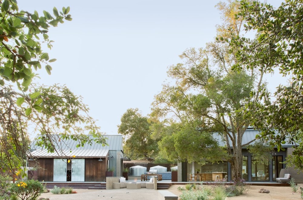 The garage has photovoltaic panels while the bike barn is clad in thermally treated wood.