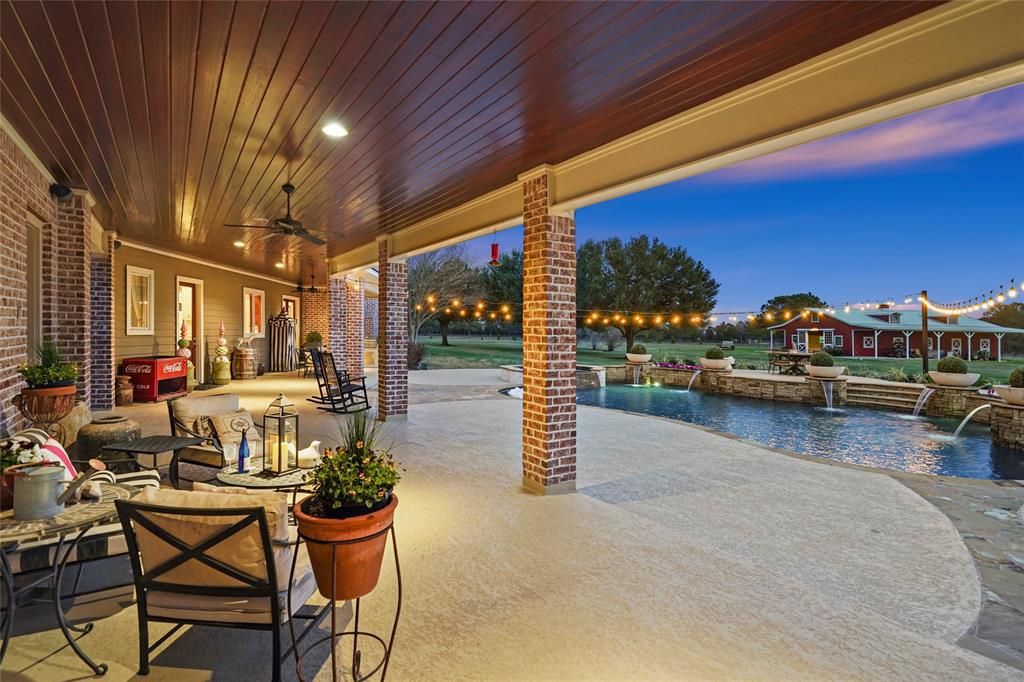 The backyard features a covered patio that overlooks the barn.