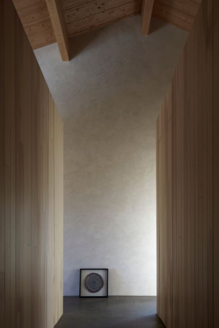 A photograph capturing the interior of a space, showcasing a clock situated on the floor in between two wooden wall dividers.