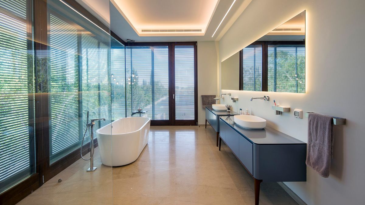 The bathroom has concrete with planks off the edges, wood doors and windows, aluminum screens.