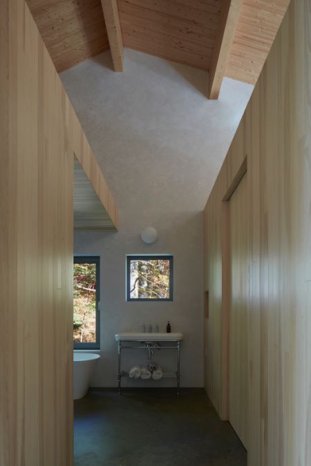 A lengthy hallway is depicted, culminating in a bathroom containing a single basin sink and a glass windows.