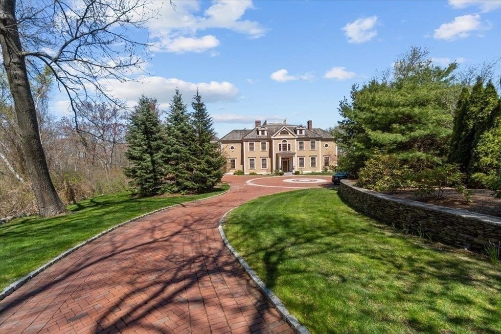 The house features a paved driveway and a front yard landscaped with plants.