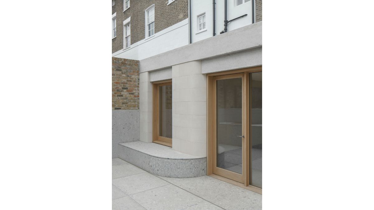 The house has a visible outer structure made of concrete, wood, and glass.