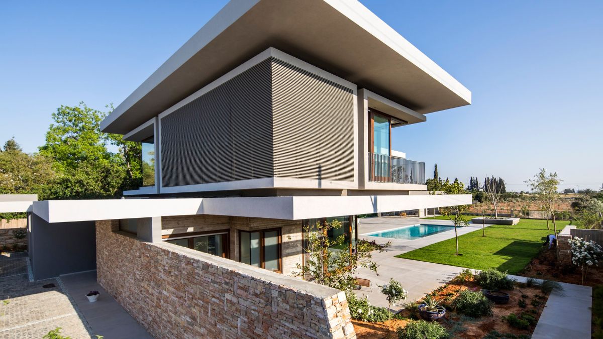 The main house's flat roof plane is the first feature of the architecture.