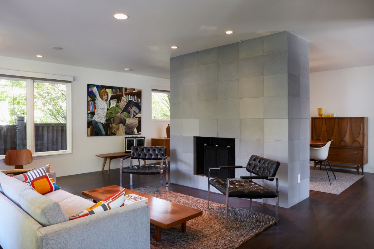 The new living room is light and airy. The main point of the space is a hearth coated in concrete tile from Sadlerstone, a material that appears throughout the building.