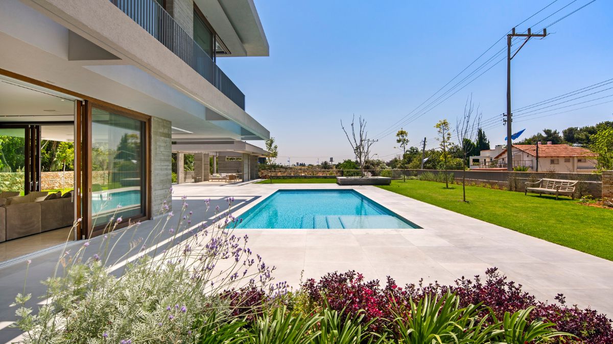 The gray tones of the house and the olive grove's subdued colors create a sense of calm and serenity.