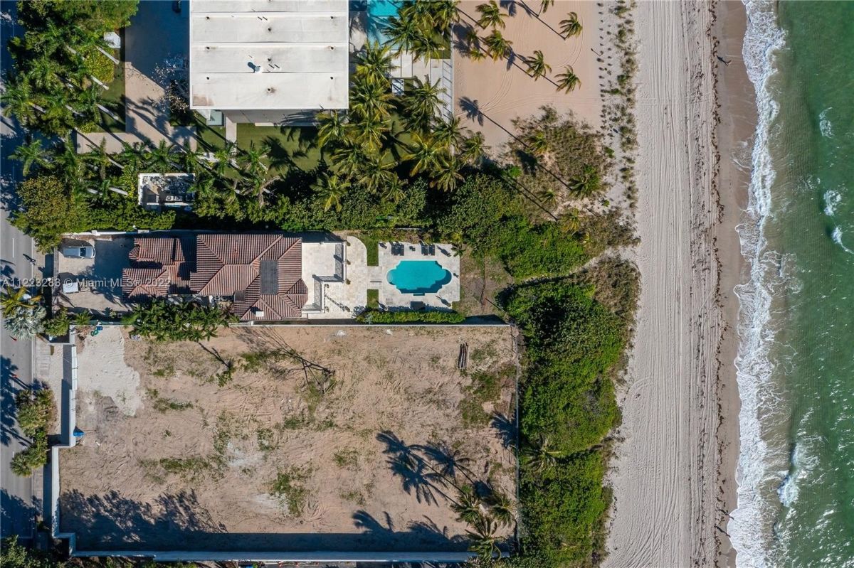 Aerial view of the house, the neighboring houses, and the beach.