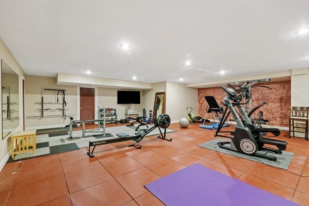 The house features a home gym with tile flooring and different kinds of gym equipment.