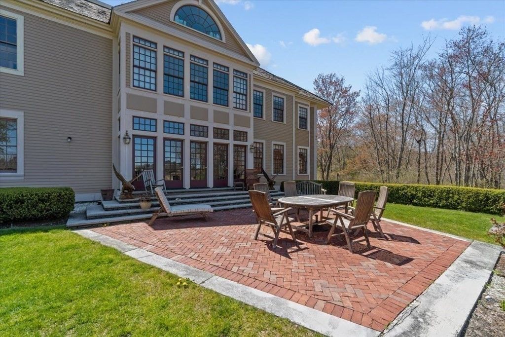 The backyard features an outdoor dining area with the brick pavement.