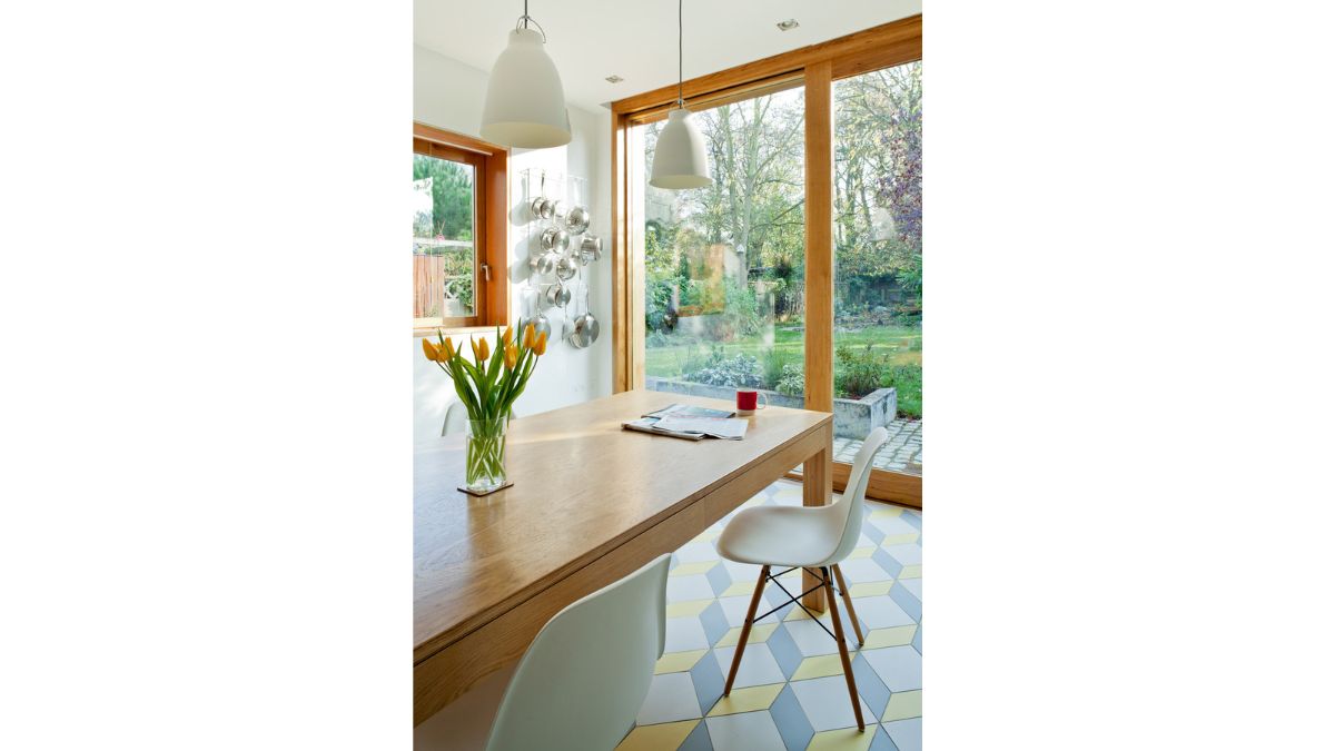 Inside, the new kitchen and larger living room form a roomy "S" shape, with big triple sliding doors leading to a decked area next to the bulk of the addition.