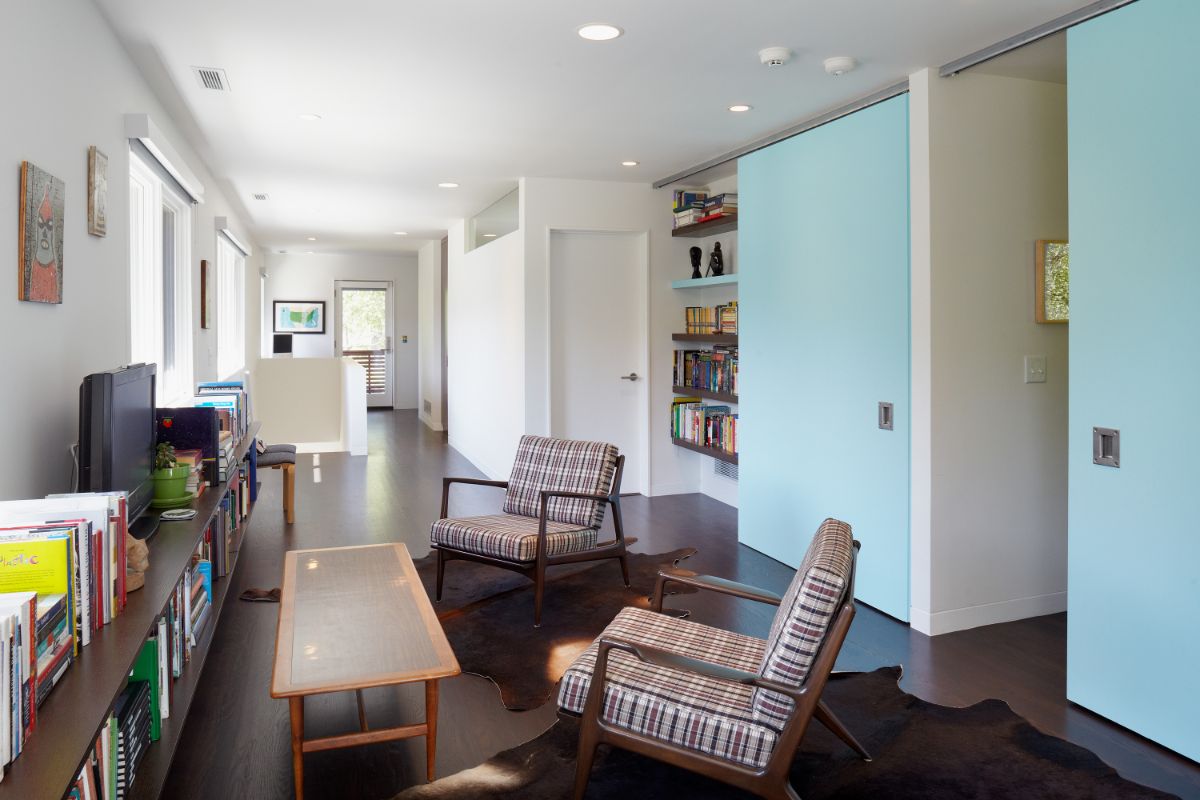 A reading area with unique powder-blue sliding doors on a Henderson track leads to the children's rooms.