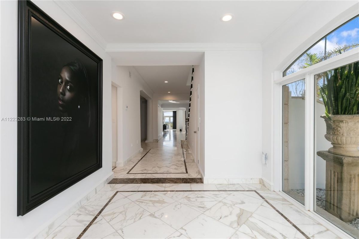 The foyer features a hallway beside the staircase with tile flooring.