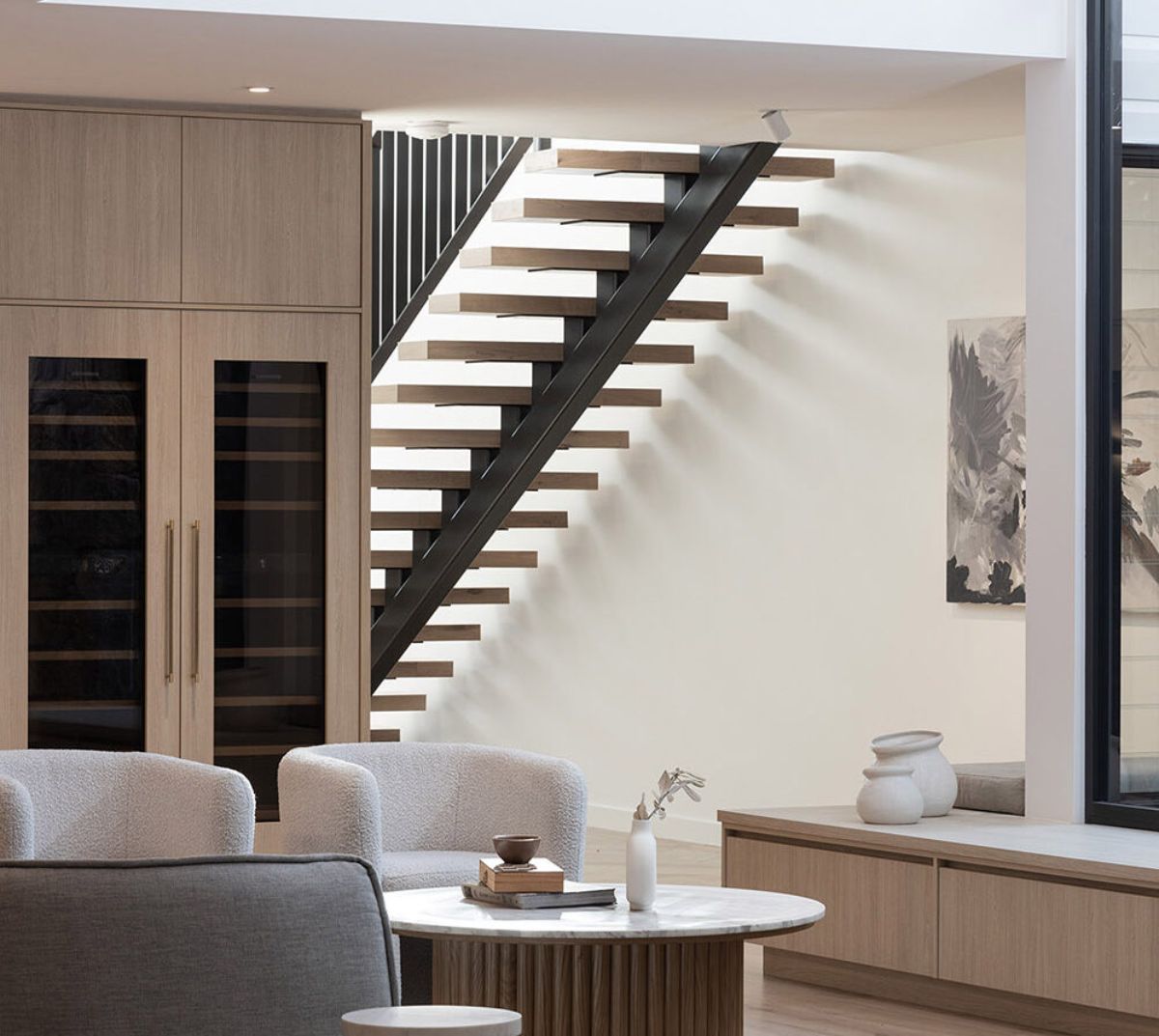 The house fixtures, including the floating stairs and cabinets, embrace a minimalist concept.