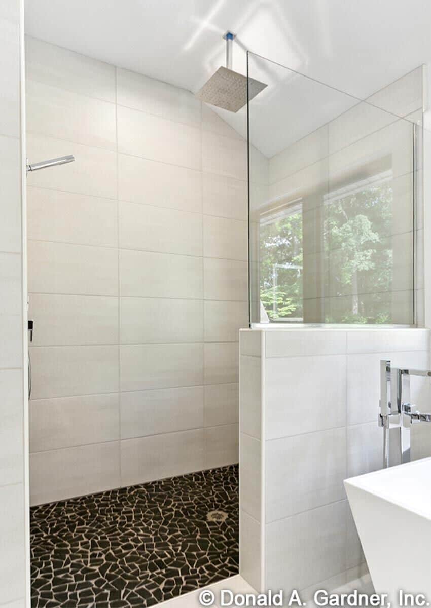 The walk-in shower has a vaulted ceiling and striking mosaic-tiled flooring.