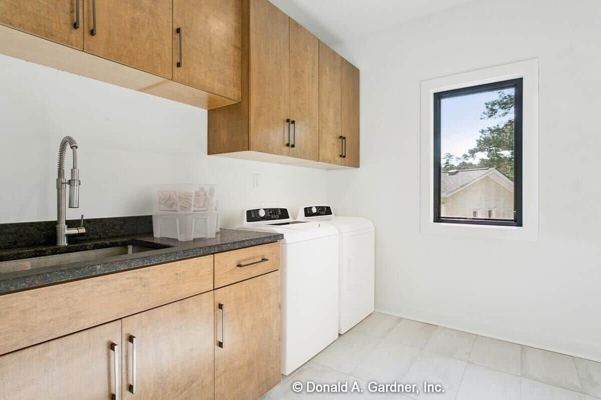 The laundry room is equipped with a top-load washer and dryer, wooden cabinets, and a utility sink.