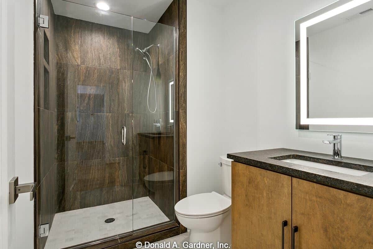 This bathroom has a granite-top vanity and a walk-in shower enclosed in a glass-hinged door.