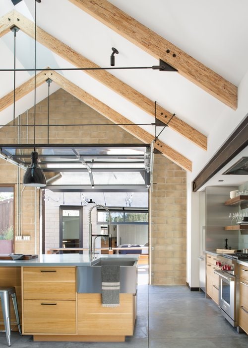 The kitchen features a cathedral ceiling, built-in appliances, and an island with cabinets.