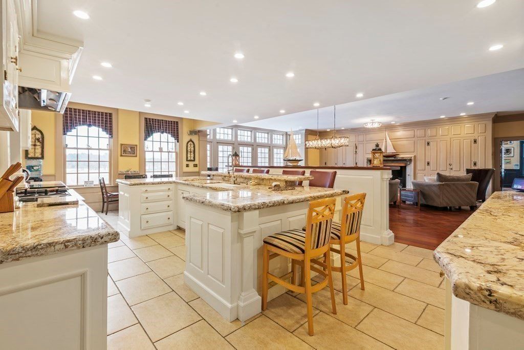 The kitchen features a kitchen bar with a granite countertop and high chairs.