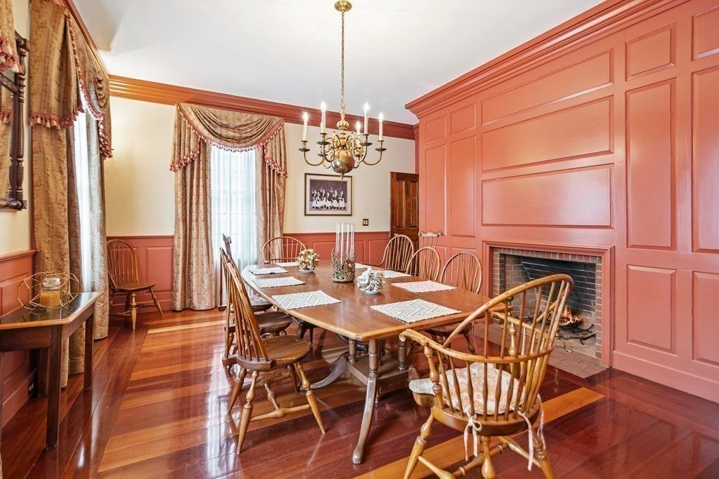 The breakfast table features a wooden table and a fireplace that gives off a cozy feel to the room.