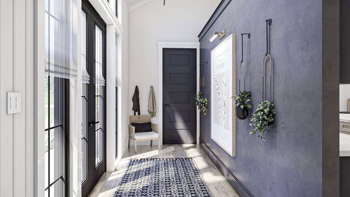 The foyer is decorated with a patterned rug, hanging plants, and framed artwork.