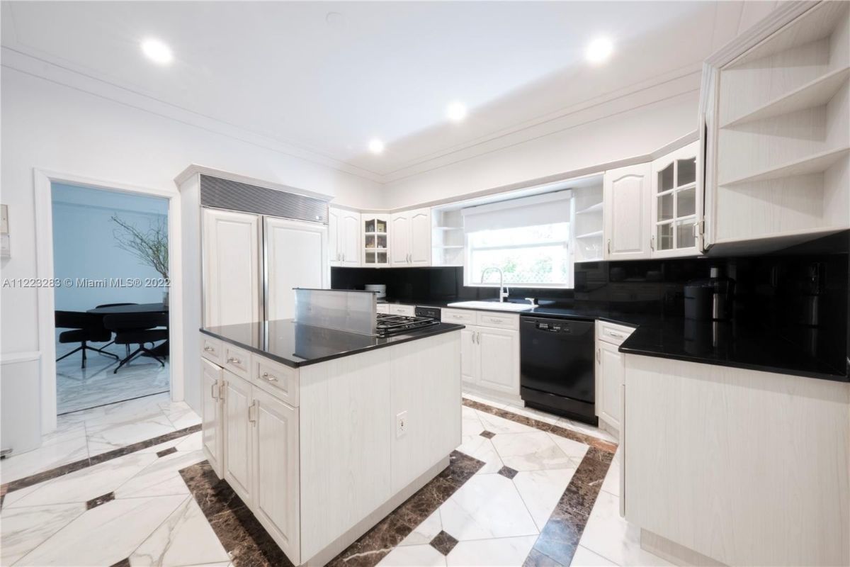 The kitchen features a kitchen island with a range and a glass countertop.