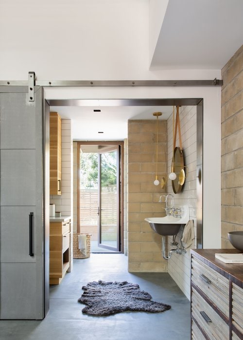 The primary bath flows right into the main space and has a direct connection to the exterior and outdoor shower. 