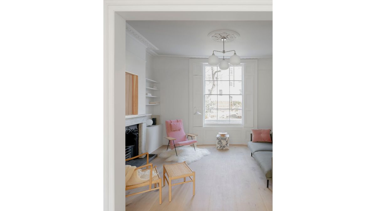 The white walls and ceiling, along with a chandelier, add brightness to the entire living area.