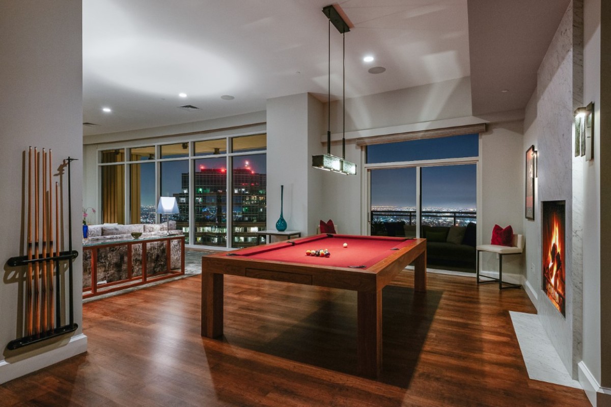 Game area with a billiards table and a cozy fireplace.