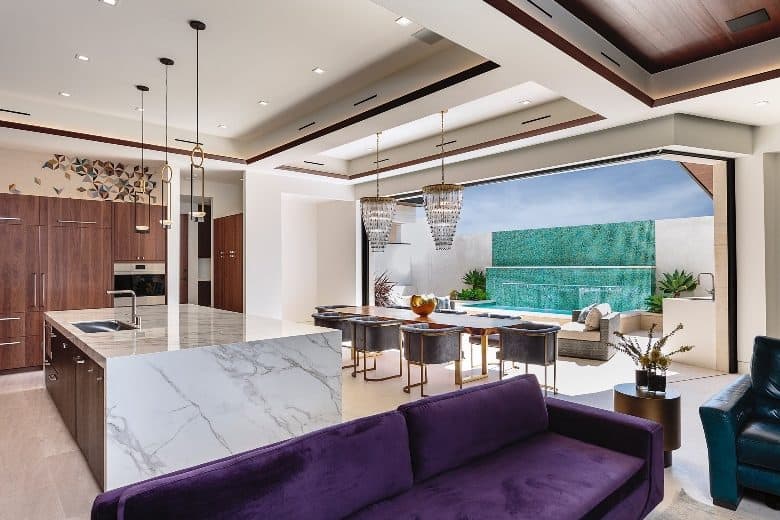 An open layout view of the living room, kitchen, and dining area filled with contemporary furnishings.