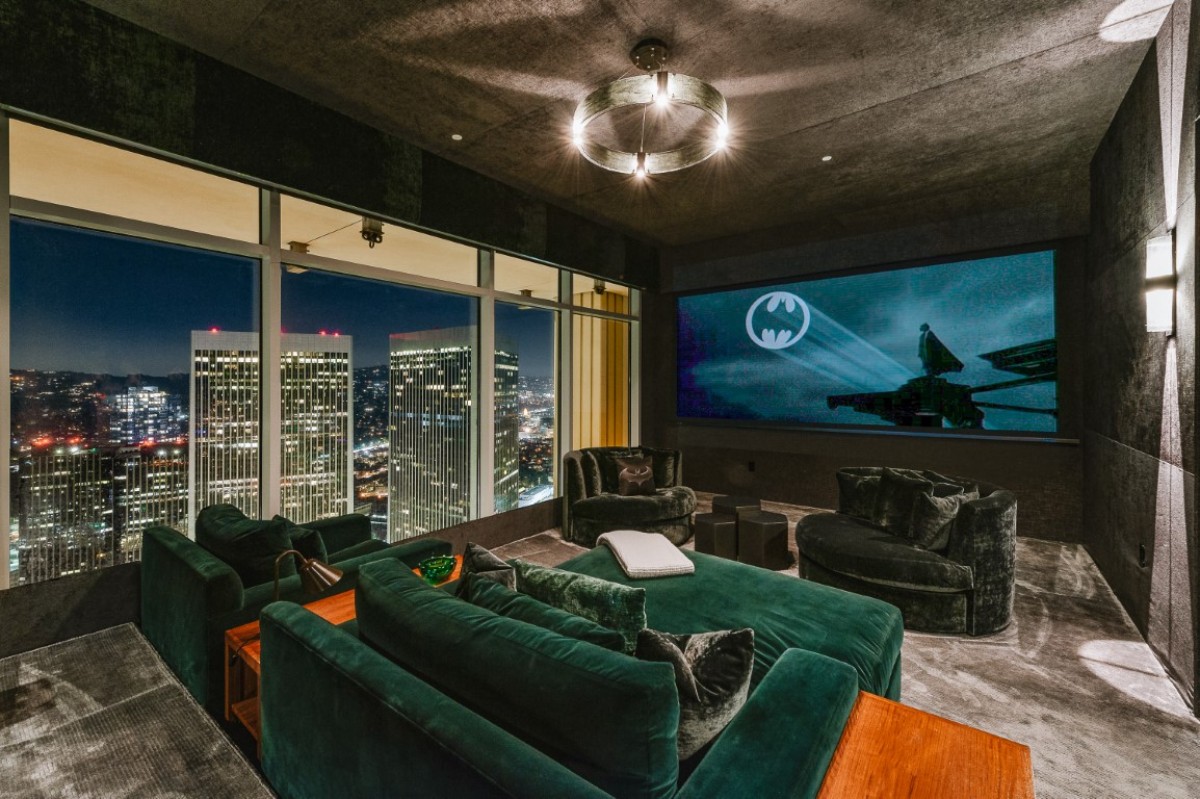 The home theater has velvet seats and a panoramic view of the sparkling city.