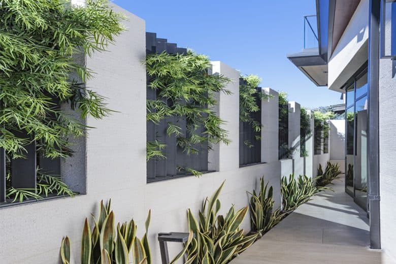 A concrete fence with metal slats provides privacy to the home.