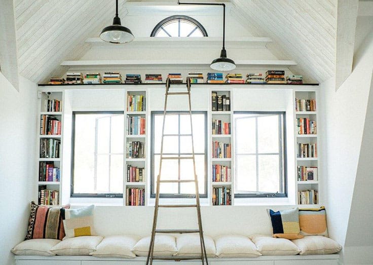 The window seat nook is used as a reading nook with built-in bookshelves and a cushioned bench.