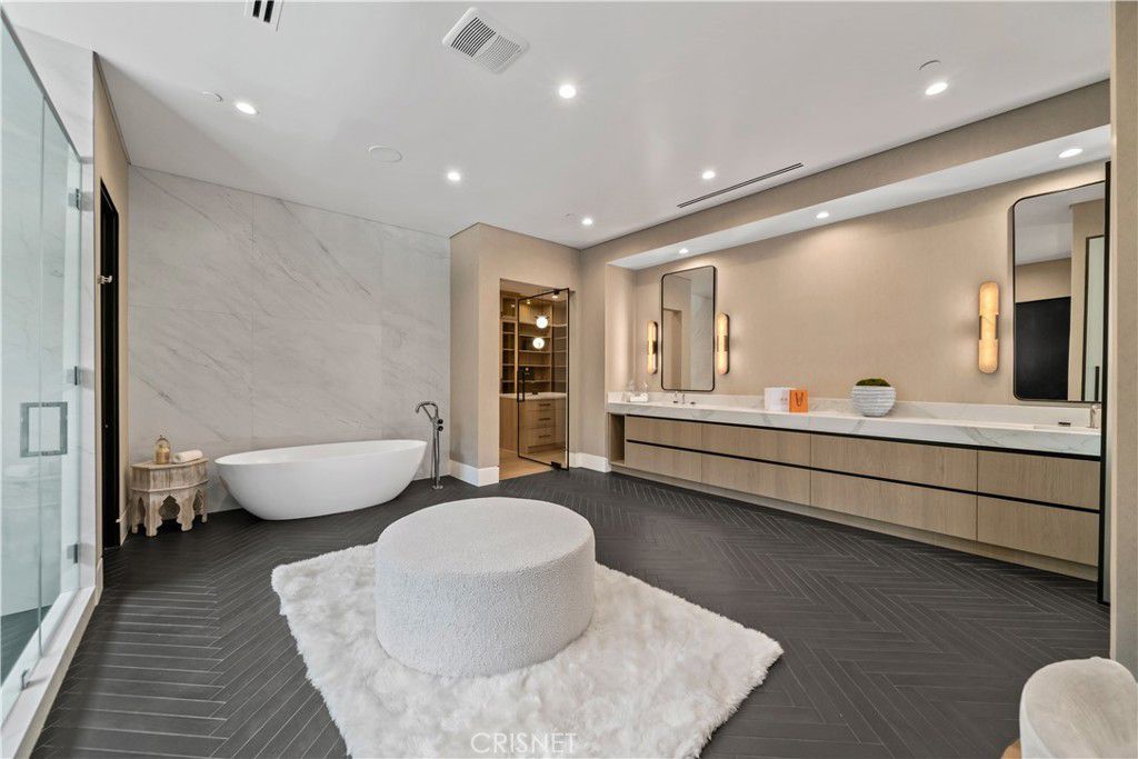 The bathroom features a vanity with a tile countertop and a free-standing bathtub.