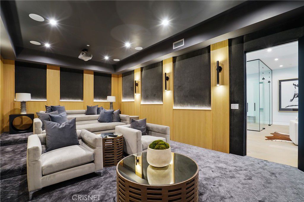 The house features a home theater with cozy sofas and wall-to-wall carpet.