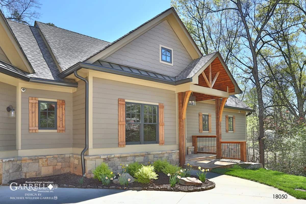 Front exterior view showcasing the shuttered windows and a covered entry porch.